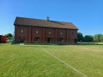 Modern village hall, two-storey building in red brick against blue sky